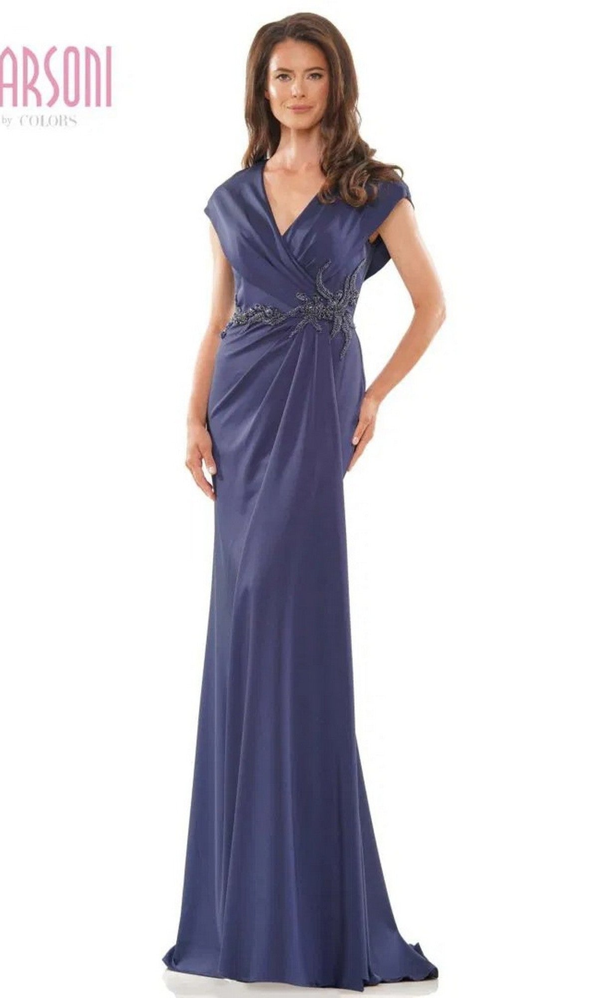 A woman is wearing the Long Formal Dress: Marsoni MV1226, a floor-length, short-sleeved navy sheath evening gown featuring a V-neck and an embellished waist detail.